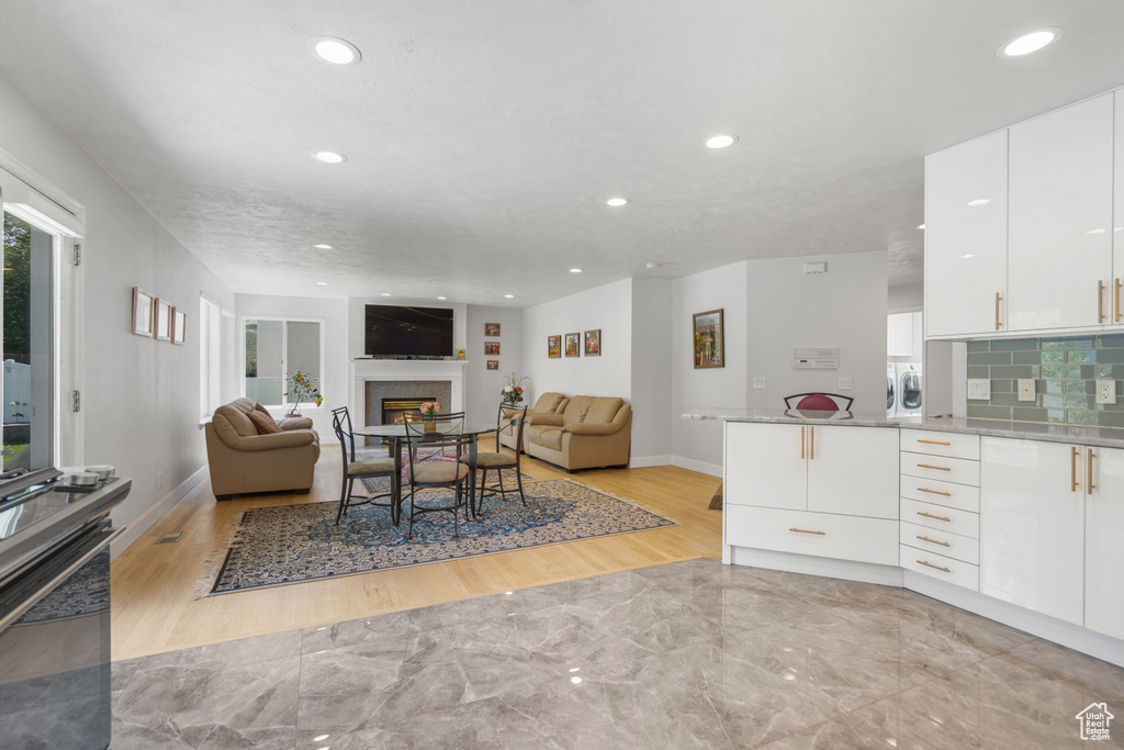 Interior space with light hardwood / wood-style flooring, tasteful backsplash, and white cabinetry