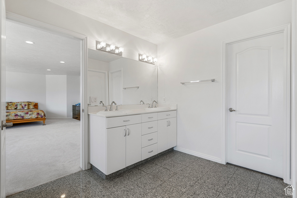 Bathroom featuring tile floors, vanity with extensive cabinet space, and double sink