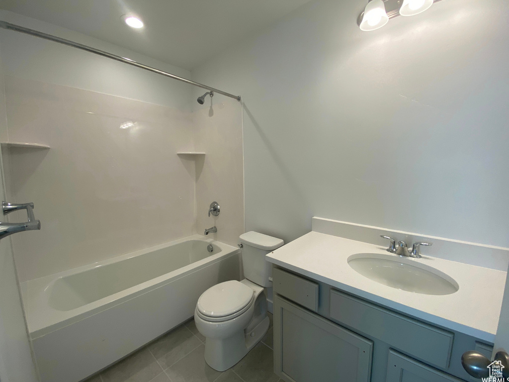 Full bathroom featuring shower / bath combination, vanity, tile floors, and toilet
