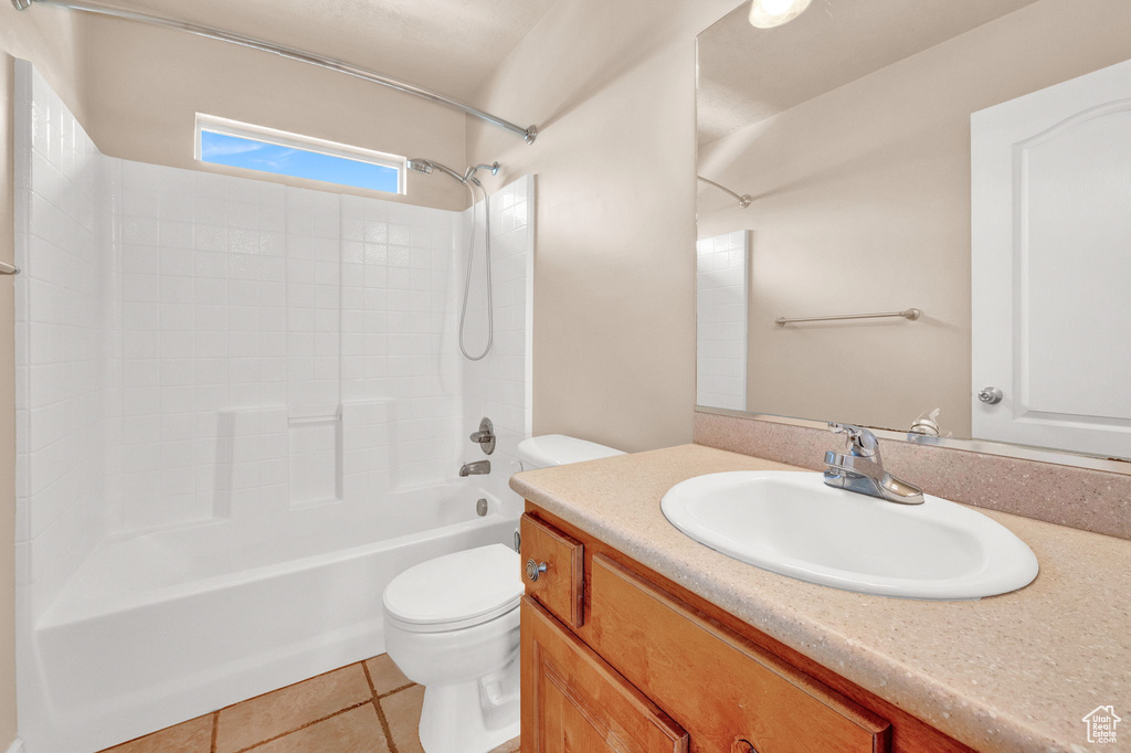 Full bathroom with tile floors, oversized vanity, toilet, and tub / shower combination