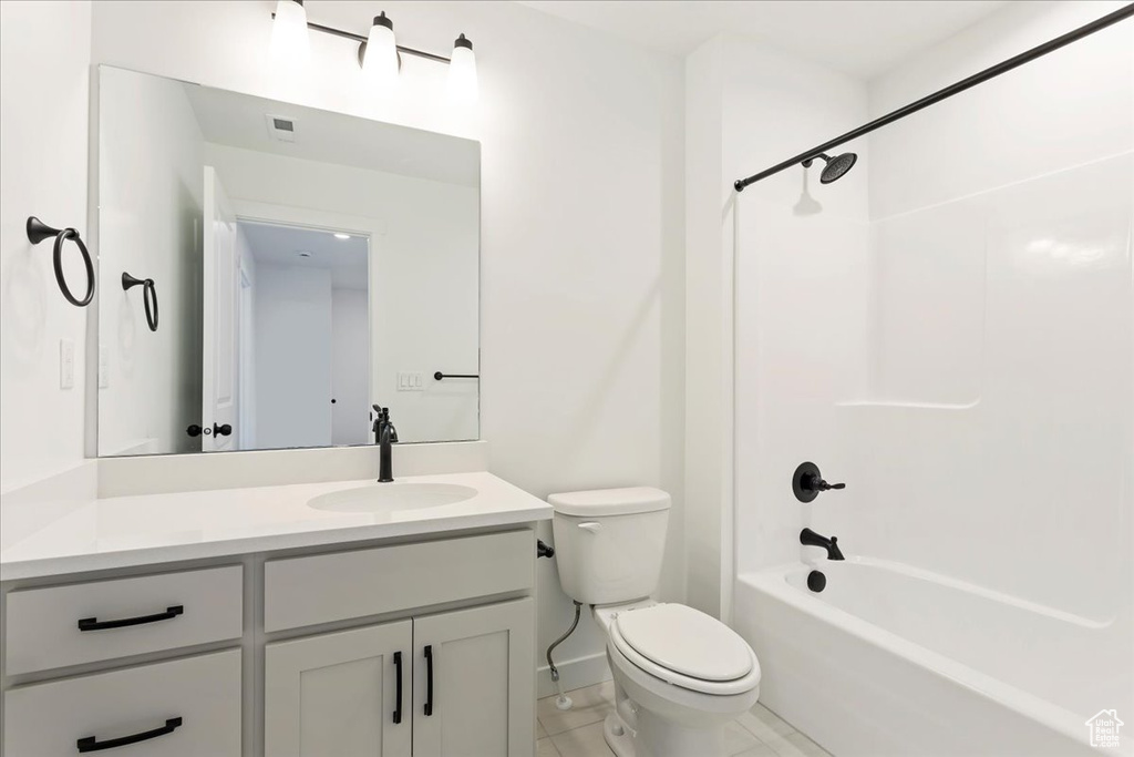 Full bathroom with tile flooring, vanity, toilet, and shower / bathtub combination