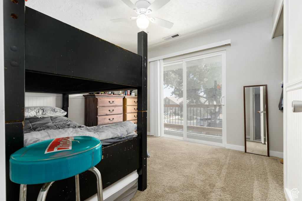 Bedroom featuring ceiling fan, carpet, and access to exterior