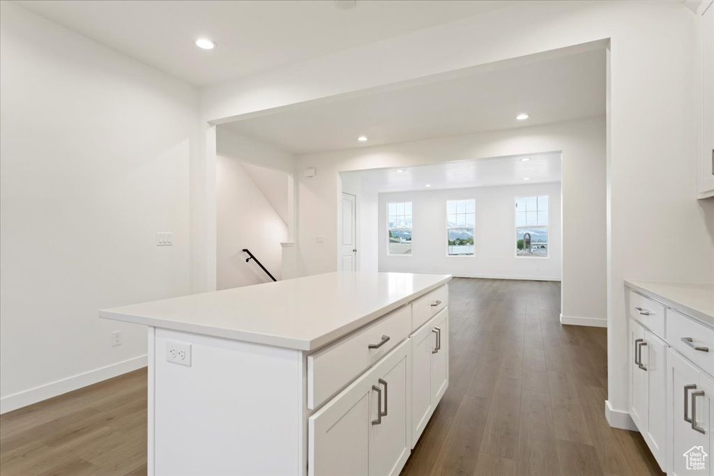Kitchen featuring white cabinets, hardwood / wood-style floors, and a center island