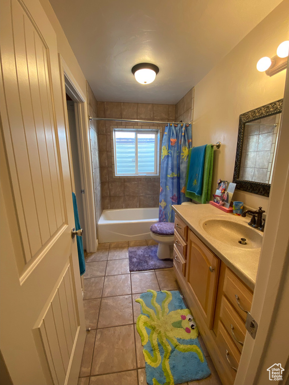 Full bathroom with toilet, tile flooring, vanity, and shower / tub combo with curtain
