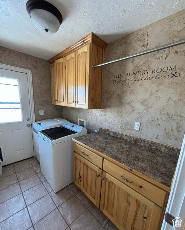 Laundry room with light tile flooring, cabinets, hookup for a washing machine, and washer and clothes dryer