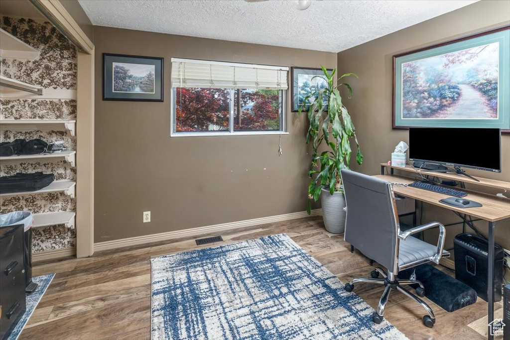 Office space featuring hardwood / wood-style flooring and a textured ceiling