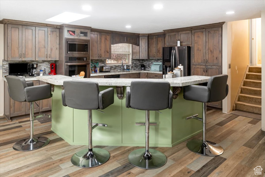 Kitchen featuring backsplash, stainless steel appliances, and light hardwood / wood-style floors