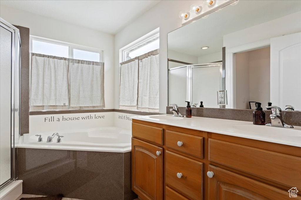 Bathroom featuring dual sinks, oversized vanity, and plus walk in shower