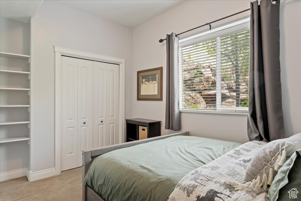Bedroom featuring carpet flooring, a closet, and multiple windows