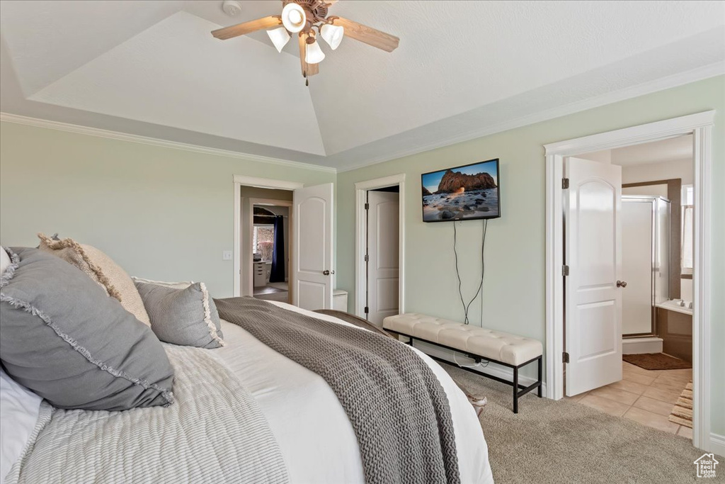 Bedroom featuring ceiling fan, light tile floors, ensuite bathroom, crown molding, and vaulted ceiling