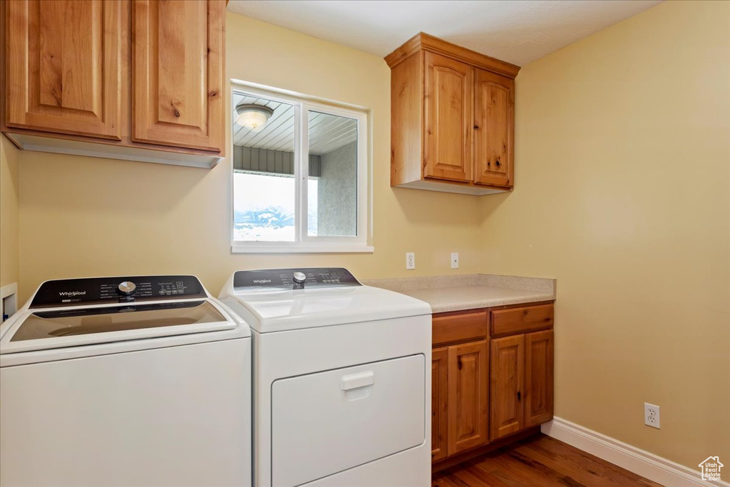 Washroom with cabinets, washer and clothes dryer, and dark hardwood / wood-style floors