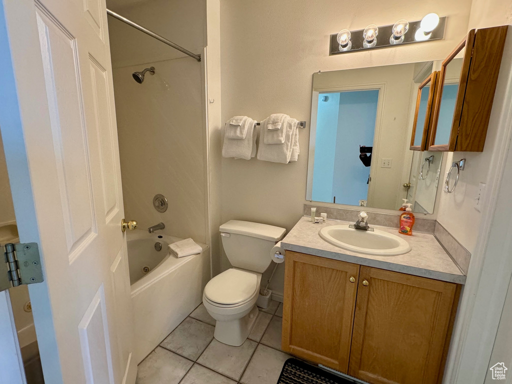 Full bathroom with bathing tub / shower combination, vanity with extensive cabinet space, toilet, and tile flooring