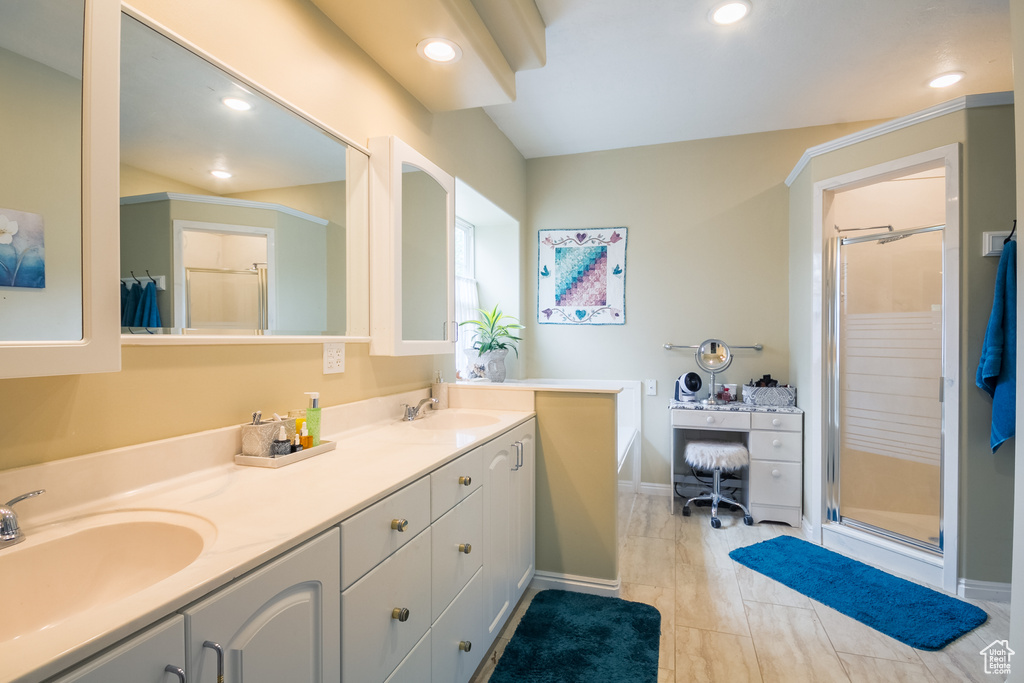 Bathroom with double vanity, tile floors, and a shower with shower door