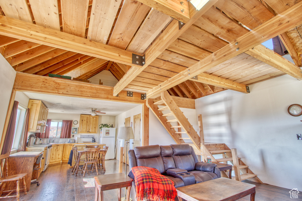 Living room featuring hardwood / wood-style flooring, wood ceiling, ceiling fan, and vaulted ceiling with beams