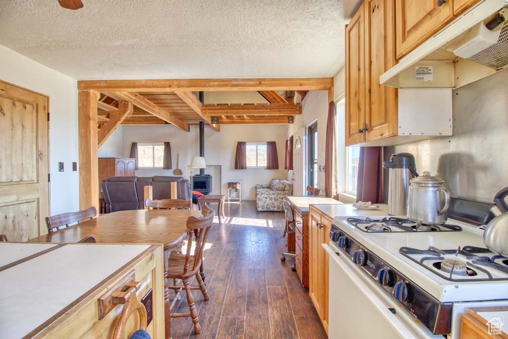 Kitchen featuring white range, dark hardwood / wood-style flooring, beamed ceiling, and a textured ceiling