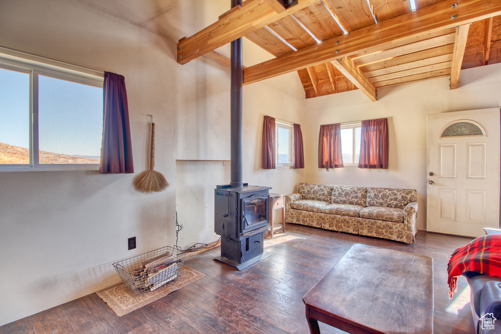 Living room with wood ceiling, dark hardwood / wood-style floors, a wood stove, and lofted ceiling with beams