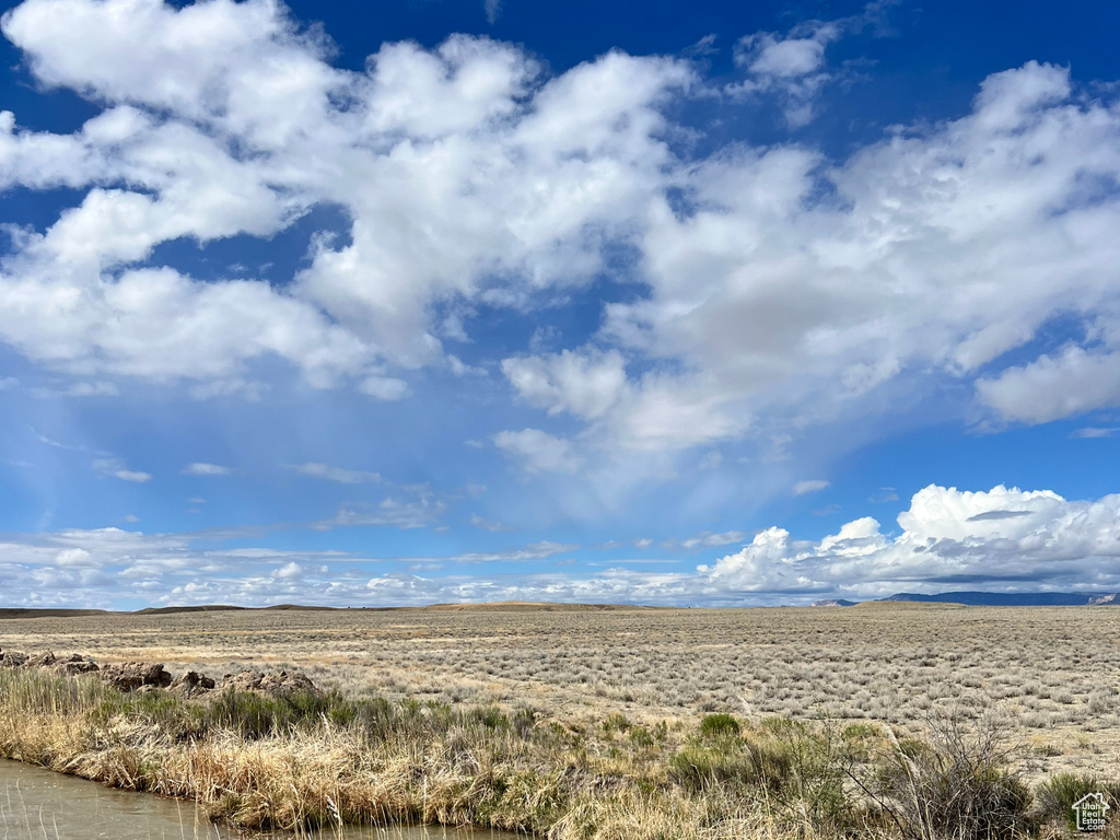 Property view of mountains with a rural view and a water view