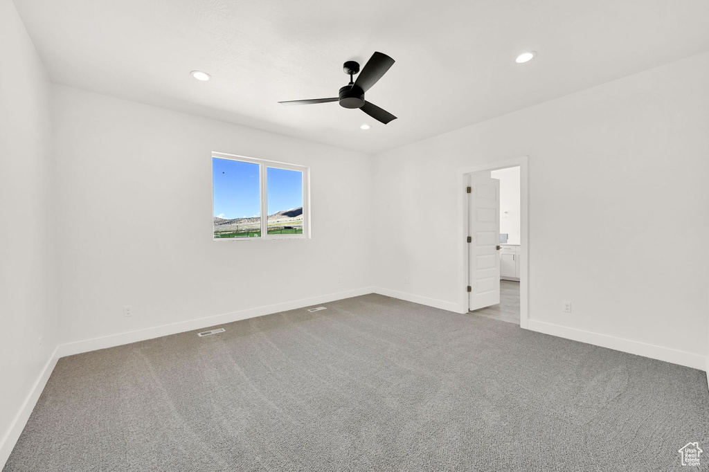 Unfurnished room with ceiling fan and carpet flooring