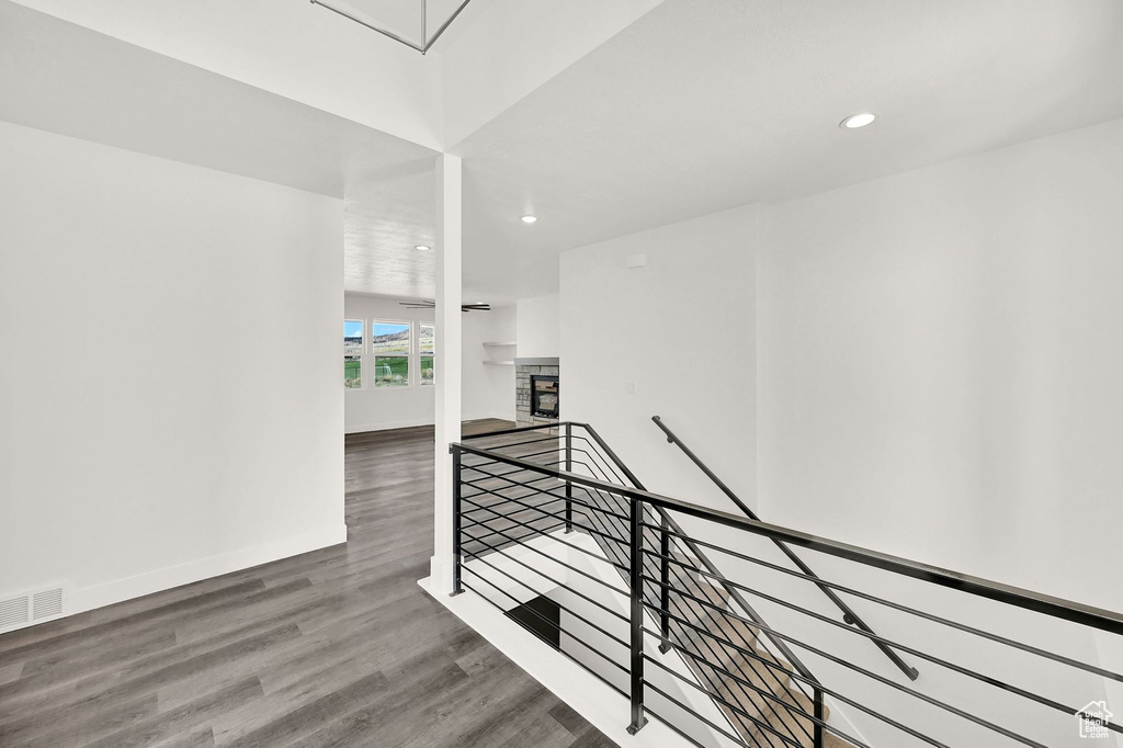 Stairway featuring hardwood / wood-style floors and a stone fireplace