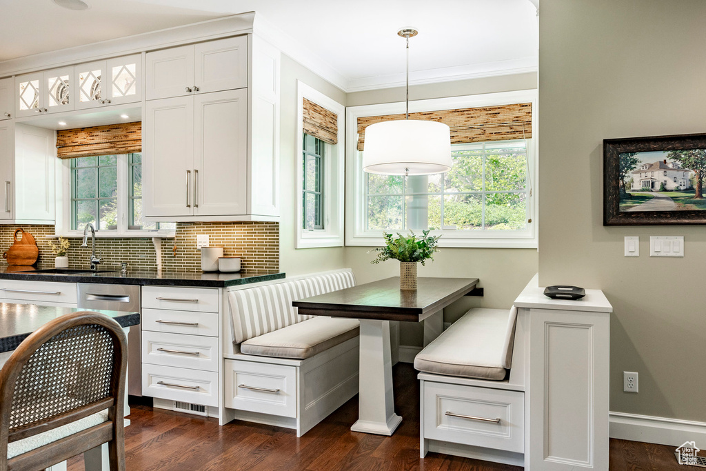 Kitchen with a healthy amount of sunlight, tasteful backsplash, and white cabinetry