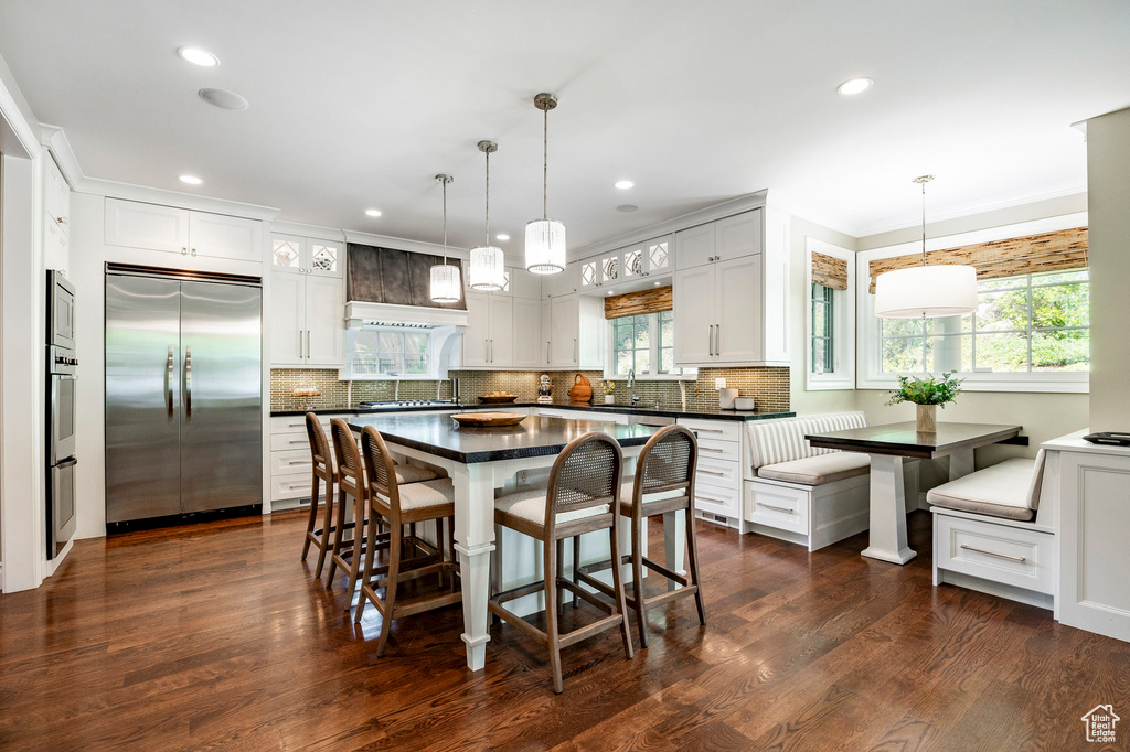 Dining area with ornamental molding and dark wood-type flooring