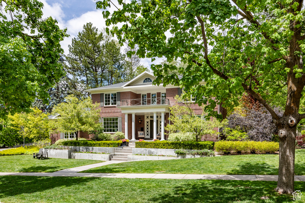 View of front of property featuring a front lawn and a balcony