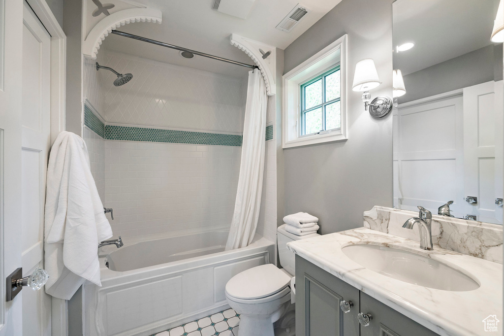 Full bathroom with oversized vanity, toilet, tile floors, and shower / bath combo with shower curtain