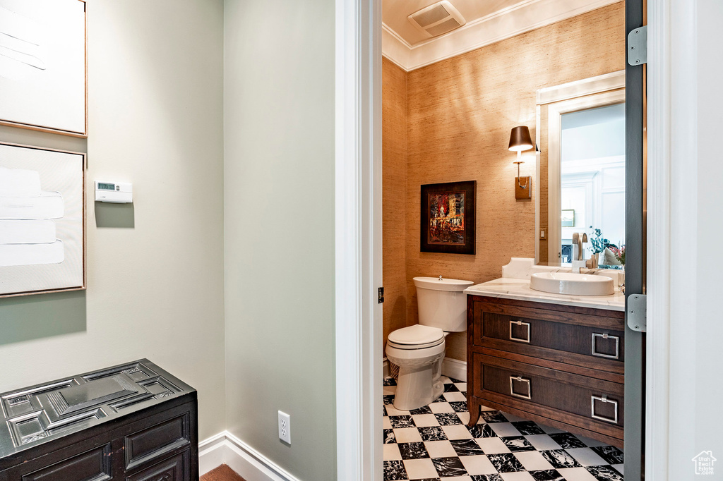 Bathroom featuring tile floors, oversized vanity, crown molding, and toilet