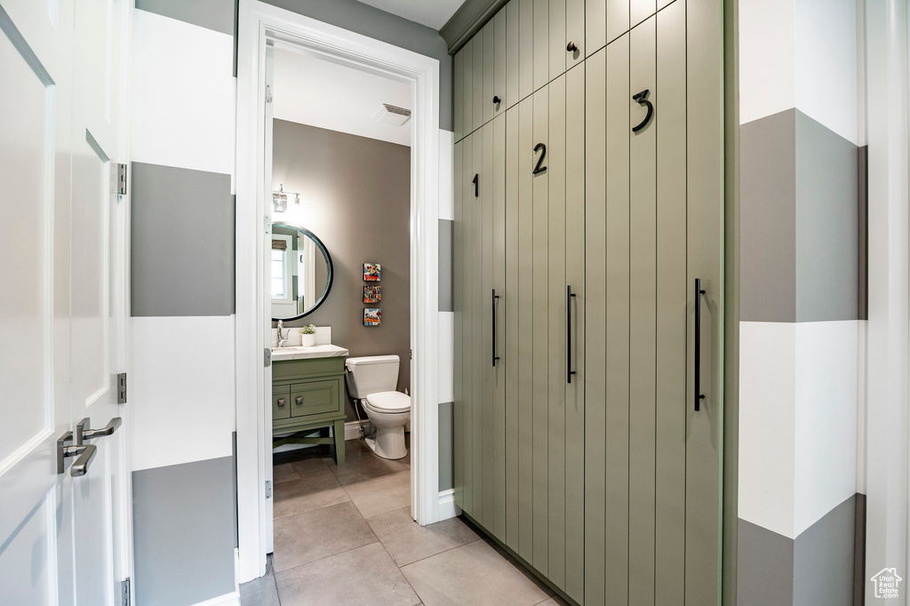 Bathroom with vanity, tile floors, and toilet