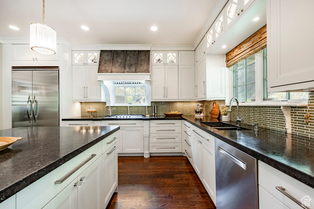 Kitchen featuring backsplash, appliances with stainless steel finishes, white cabinets, and dark hardwood / wood-style floors