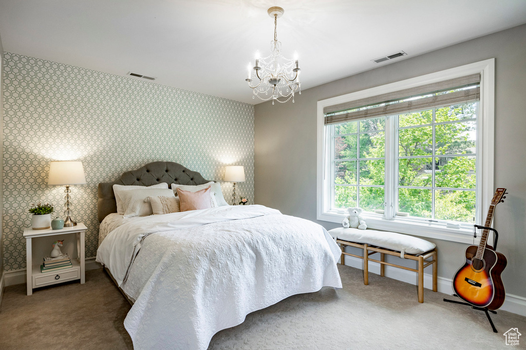 Carpeted bedroom featuring a chandelier