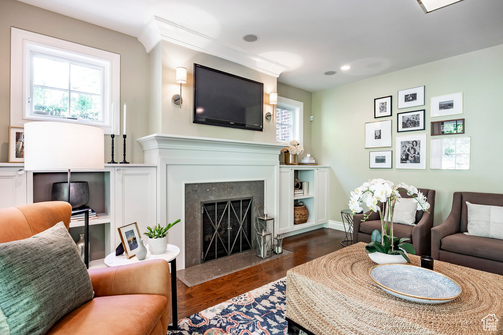 Living room featuring dark wood-type flooring and a high end fireplace