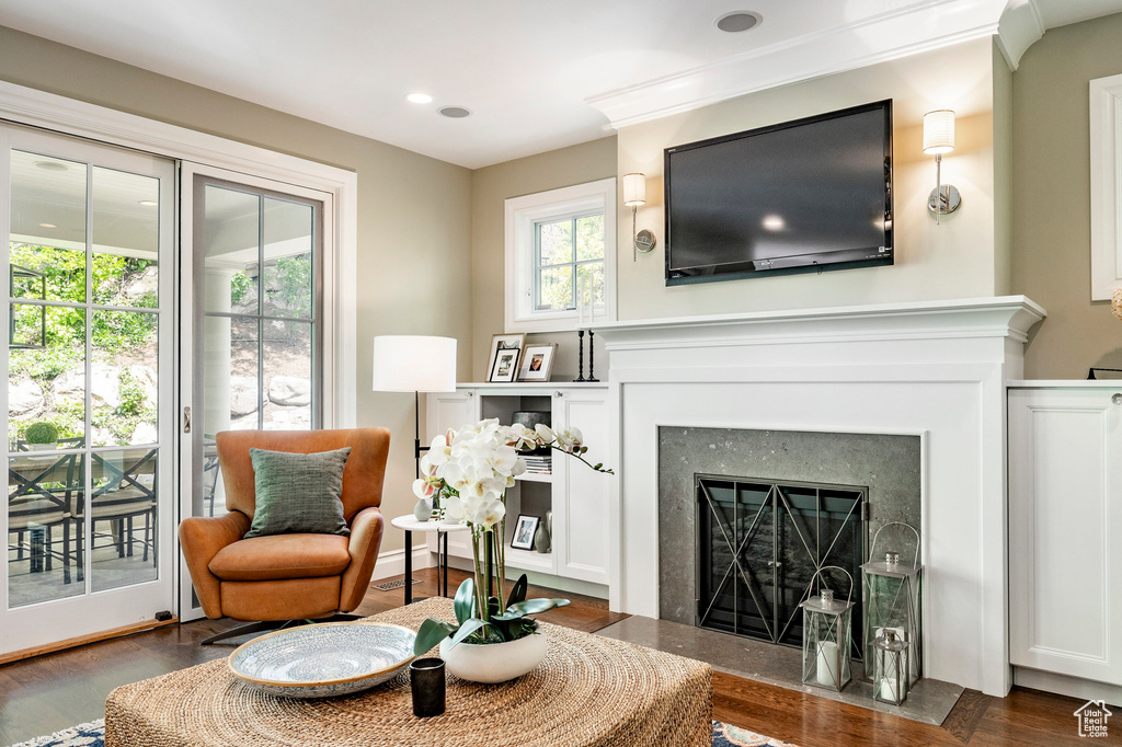 Living area with dark hardwood / wood-style floors and crown molding