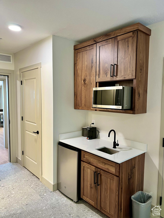 Kitchen featuring refrigerator and sink