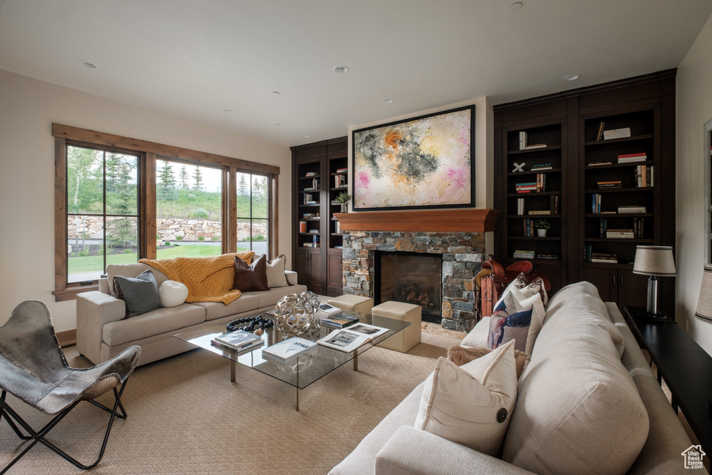 Living area featuring built in shelves and a stone fireplace