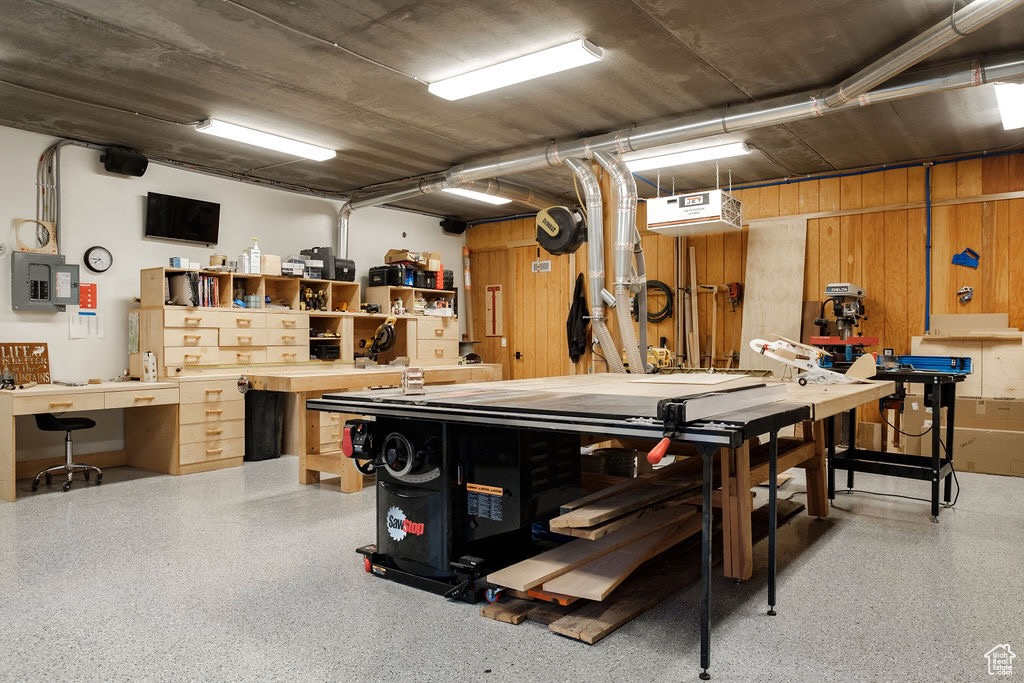 Recreation room featuring wooden walls and a workshop area