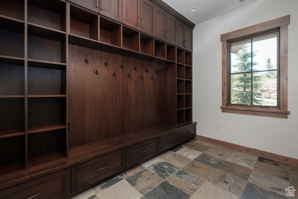 Mudroom featuring baseboards and light stone finish floors
