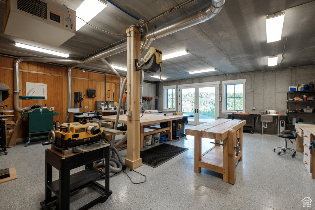 Below grade area with a workshop area, a heating unit, and french doors