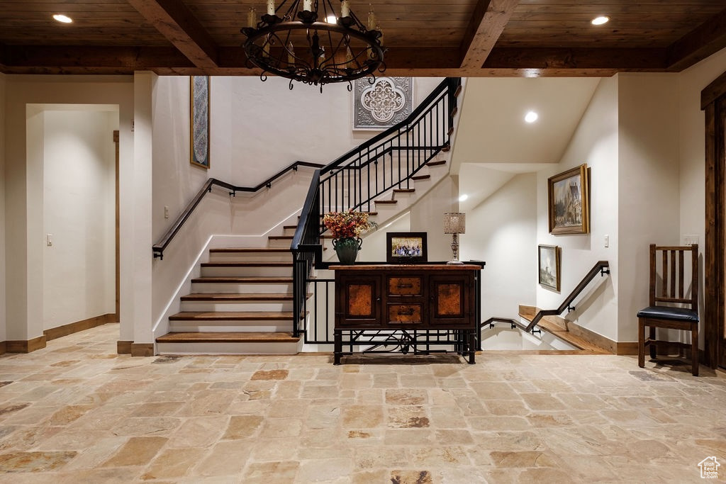 Stairway featuring beamed ceiling, an inviting chandelier, and wood ceiling