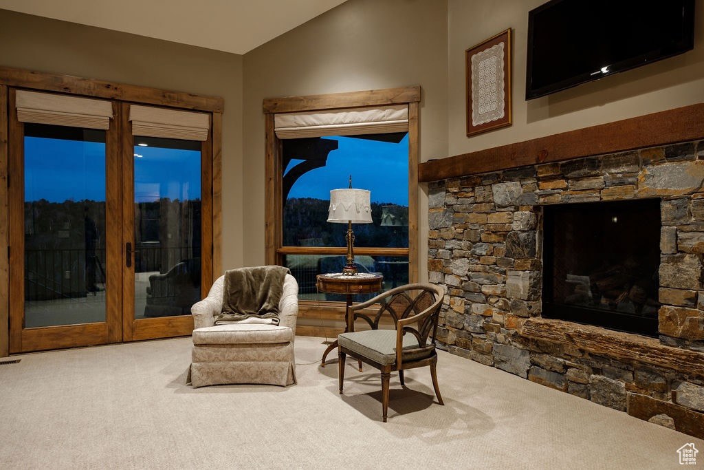 Interior space featuring a fireplace, carpet, and vaulted ceiling