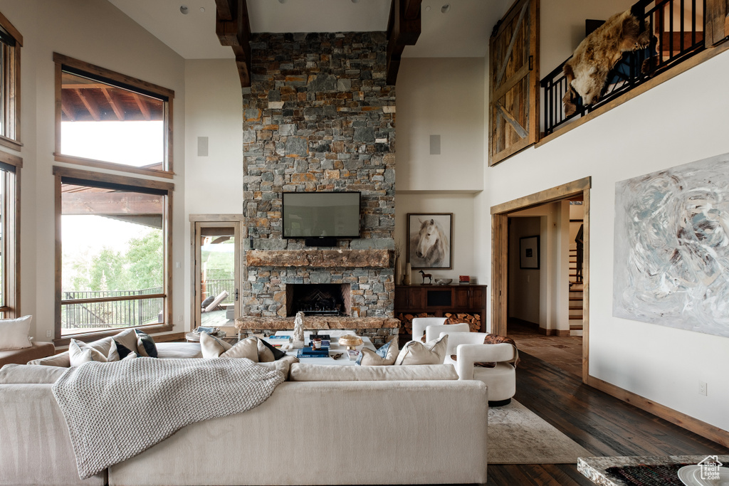 Living room featuring a fireplace, a high ceiling, and wood finished floors