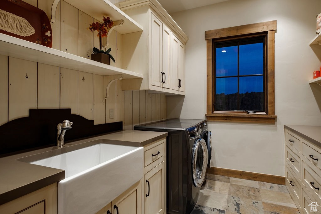 Laundry room featuring cabinets, sink, independent washer and dryer, and light tile flooring