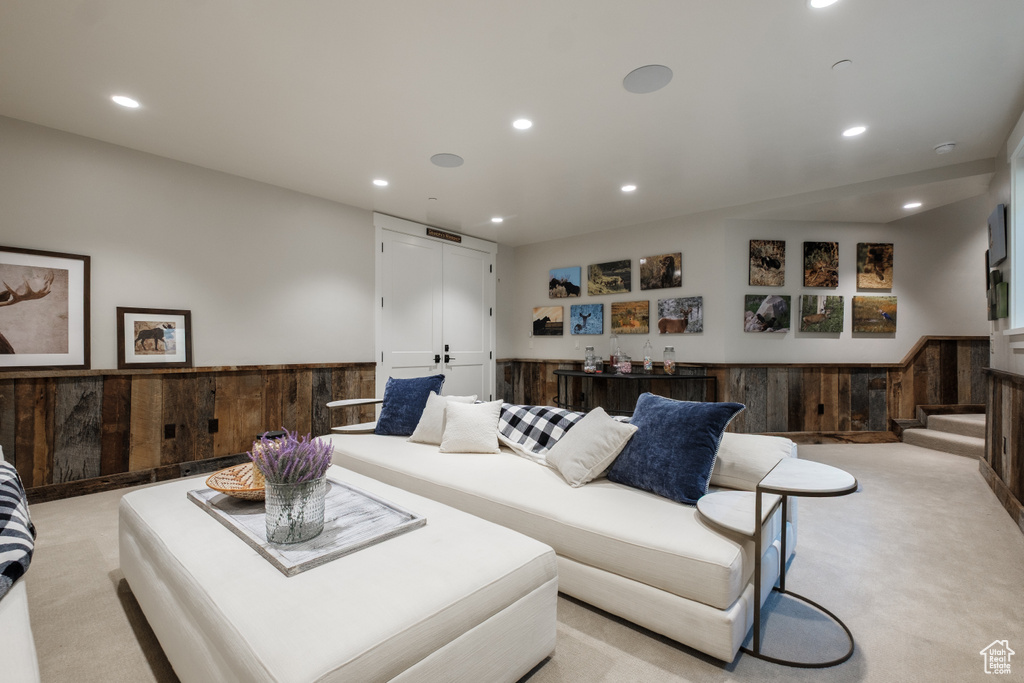 Living area with light carpet, recessed lighting, and a wainscoted wall