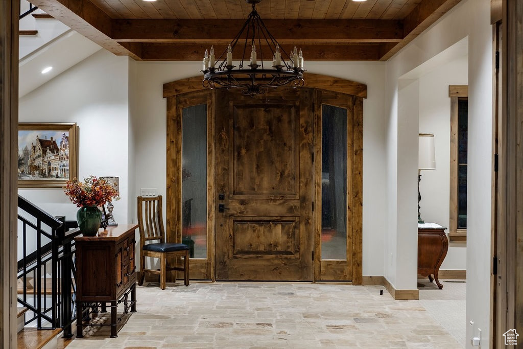 Entryway featuring vaulted ceiling with beams, a chandelier, and wood ceiling