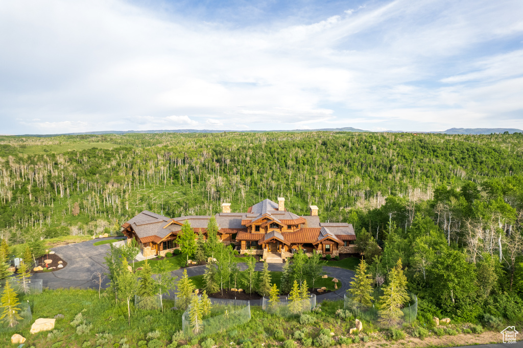 Aerial view of property and surrounding area featuring a forest