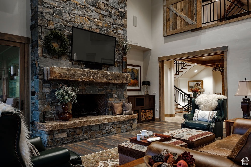 Living room featuring a towering ceiling, hardwood / wood-style flooring, and a fireplace