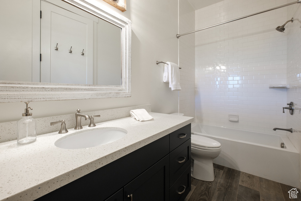 Full bath featuring wood finished floors, bathing tub / shower combination, and vanity