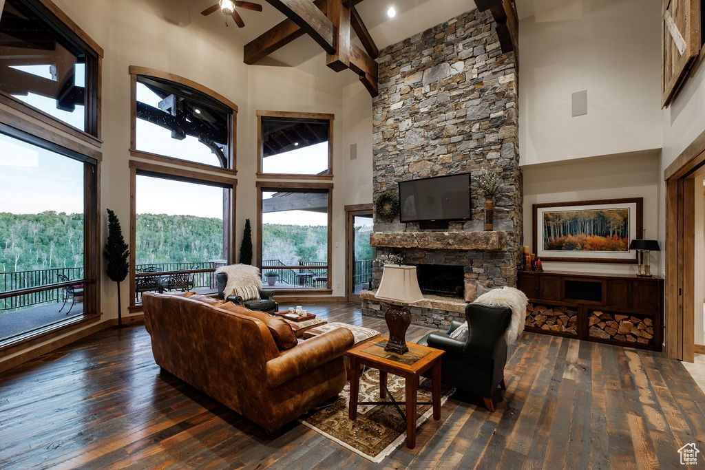 Living room with high vaulted ceiling, dark wood-type flooring, and a stone fireplace