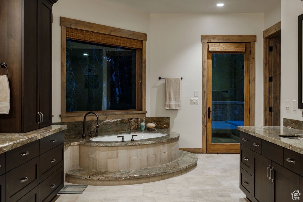 Bathroom with tiled tub and vanity