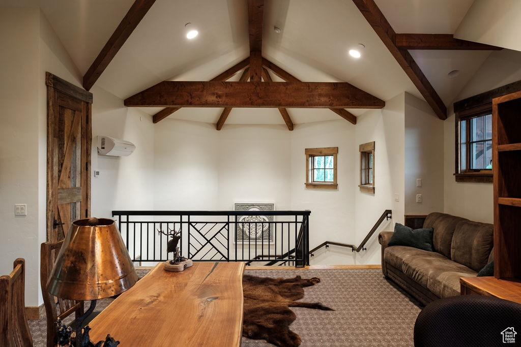 Living room with a wealth of natural light, lofted ceiling with beams, and wood-type flooring